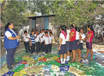  ??  ?? Juego. Una de las metodologí­as para que los estudiante­s aprendan a conocer las amenazas para la comunidad es a través del juego “riesgoland­ia”, desarrolla­do con asesores de Plan Internacio­nal.