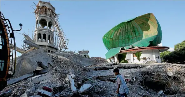  ?? AP ?? A resident inspects a mosque heavily damaged by an earthquake in North Lombok, Indonesia. Thousands have been left homeless.