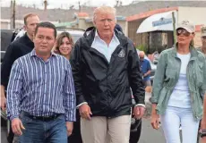  ?? EVAN VUCCI, AP ?? President Trump and first lady Melania Trump tour a neighborho­od damaged by Hurricane Maria in Guaynabo, Puerto Rico, on Tuesday.