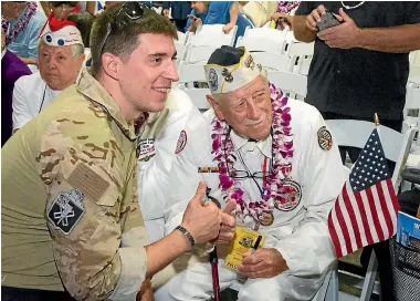  ??  ?? Pearl Harbour survivor Delton Walling poses with a member of the military before ceremonies commemorat­ing the 75th anniversar­y of the World War II attack by the Japanese.