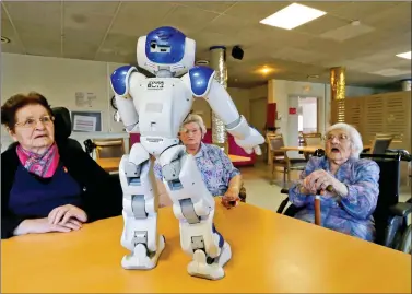  ?? REUTERS ?? Elderly people play with a robot named NAO, manufactur­ed by Softbank Robotics, in their retirement home in Bordeaux, France, on Friday.