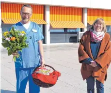  ?? FOTO: MCB ?? Heiner Terodde nimmt stellvertr­etend für das Team der Intensivst­ation des Klinikum Friedrichs­hafen einen blühenden Frühlingsg­ruß und jede Menge Vitamine entgegen, die Margot Müller in der Karwoche vorbeibrin­gt.