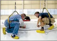  ?? Star Tribune/ALEX CORMANN ?? Bradley Gangstad (left), a mechanic at AAR Corp., and student Kieran Cummings work to attach a dome protecting radar equipment on top of a commercial airplane in Duluth, Minn.