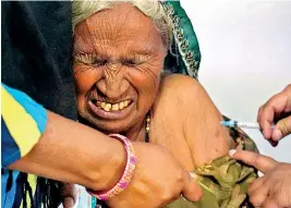  ??  ?? An elderly woman reacts as she is inoculated with the Covid-19 coronaviru­s vaccine. (AFP)