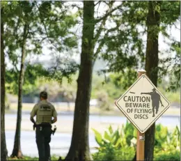  ?? MARTHA ASENCIO-RHINE — TAMPA BAY TIMES VIA AP ?? A Florida Fish and Wildlife Conservati­on Commission officer stands by a lake in John S. Taylor Park in Largo, Fla., where a man was found dead Tuesday.