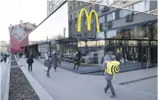  ?? ?? People walk past a McDonald’s restaurant in Moscow in March. McDonald’s has pulled out of Russia entirely in response to its invasion of Ukraine.