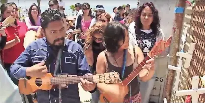  ??  ?? Músicos tocan del lado de tijuana justo al pie de la malla metálica que divide a las dos naciones