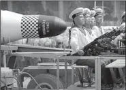 ?? AP/WONG MAYE-E ?? North Korean leader Kim Jong Un watches the parade Saturday in Pyongyang. Among the hardware was a submarine-launched ballistic missile (right photo). A similar missile, launched near a submarine base after the parade, was a failure, according to the...