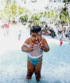  ??  ?? Splashing time: A boy playing in the wading pool at the KLCC Park.