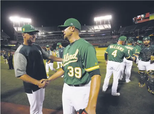  ?? Michael Zagaris / Getty Images ?? Manager Bob Melvin congratula­tes All-Star reliever Blake Treinen after the A’s beat Cleveland in June during their 21-6 run before the break.