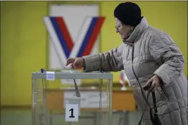  ?? DMITRI LOVETSKY — THE ASSOCIATED PRESS ?? A woman casts a ballot at a polling station located in the school gymnasium during a presidenti­al election in St. Petersburg, Russia, Friday. Voters in Russia are heading to the polls for a presidenti­al election that is all but certain to extend President Vladimir Putin's rule after he clamped down on dissent.