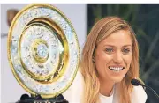  ?? FOTO: DPA ?? Angelique Kerber (30) präsentier­t in Stuttgart ihre Wimbledon-Trophäe.