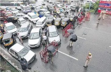  ?? REUTERS ?? Indian security personnel stand guard as they stop traffic during restrictio­ns in Jammu yesterday.