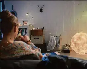  ??  ?? Une lampe en forme de lune donne un cachet douillet à son salon.