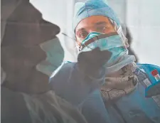  ?? JON GAMBRELL/AP ?? A Nevada hospital was warned not to use any of 250,000 donated test kits from a UAE company that partnered with China. Above, a technician takes a nasal swab in Abu Dhabi.