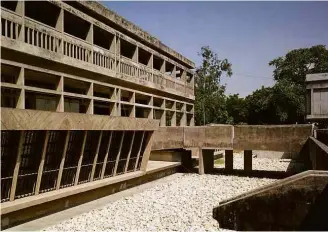  ?? View Pictures/UIG via Getty Images ?? Doshi comemora Pritzker mostrando uma de suas telas; ao lado, o prédio de um instituto de estudos sobre a Ásia meridional em Gujarat, na Índia