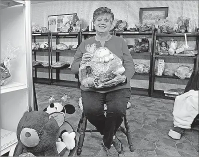  ?? [MARY BETH LANE/DISPATCH] ?? Kay Burns displays a Hello Kitty gift package Thursday at the Sparrow House, an outreach ministry of South Perry United Methodist Church in Hocking County. Burns and other volunteers organize a gift shop where area parents and grandparen­ts in need can...