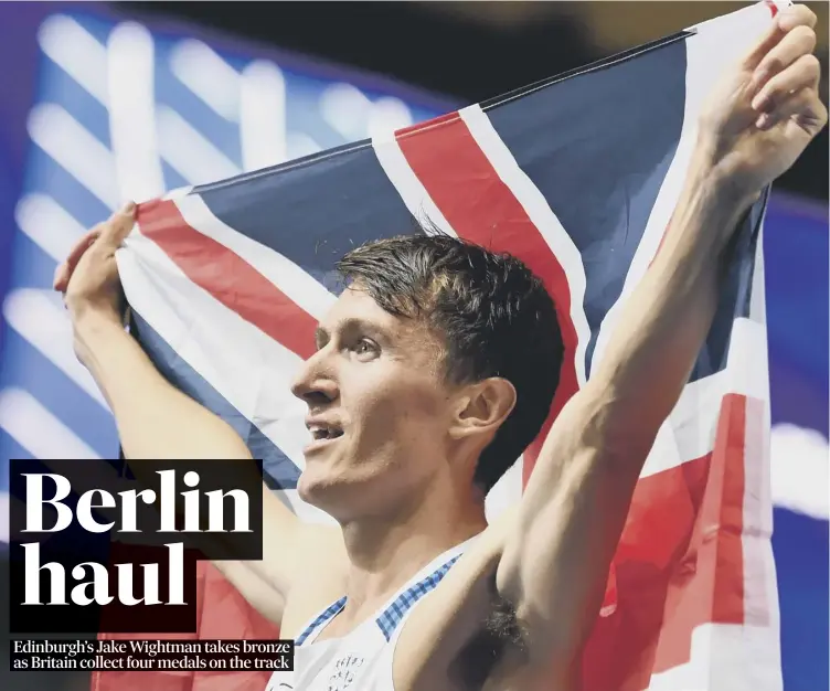  ??  ?? A delighted Jake Wightman waves his Union flag in the Olympic Stadium after finishing third in the 1,500 metres in last night’s European Championsh­ips action in Germany.