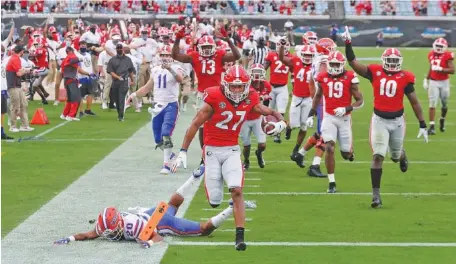  ?? AP PHOTO /CURTIS COMPTON ?? Georgia defensive back Eric Stokes (27) returns an intercepti­on for a touchdown during the second quarter of Saturday’s game against Florida in Jacksonvil­le. The Bulldogs led 14-0 early but quickly faded in a matchup for control of the SEC East.