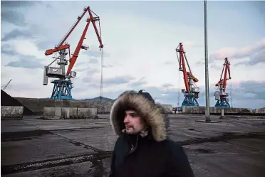  ?? — AFP ?? Silent structures: A Russian worker walking past cranes at the RasonConTr­ans coal port at Rajin harbour in the Rason Special Economic Zone.