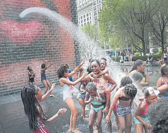  ?? Afp ?? Un grupo de chicos juega con agua, ayer, en un barrio de Chicago, que soportó 46,1°C