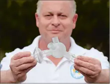  ?? DANA JENSEN/THE DAY ?? Robert Conley of Lebanon, owner of Interactiv­e CAD Solutions, on Wednesday holds the ventilator quad hose splitter, the white piece, that he designed, attached to a stock HEPA filter and a stock coupling that connects to a ventilator.