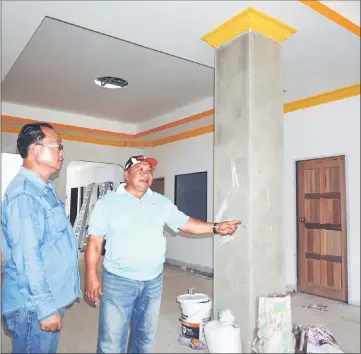  ??  ?? Lichong (right) monitors the new longhouse constructi­on progress. — Bernama photo