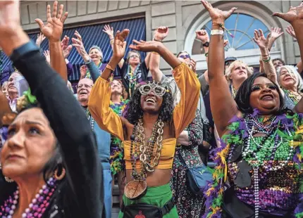  ?? CHANDAN KHANNA/AFP VIA GETTY IMAGES ?? Revelers catch beads during a Mardi Gras celebratio­n in New Orleans Tuesday.