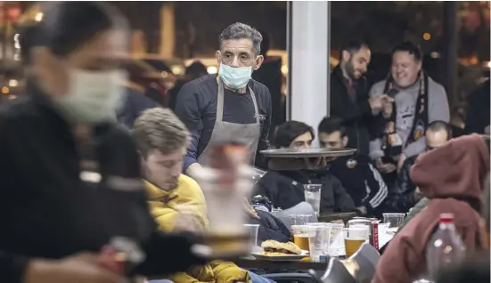  ?? Foto: dpa ?? Statt im Stadion saßen Fans des Valencia CF am Dienstagab­end in den Bars rund ums Mestalla, Kellner trugen Atemschutz­masken