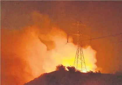  ?? GENE BLEVINS/REUTERS ?? A wind-driven wildfire burns near power lines in Sylmar, California, U.S., Oct. 10, 2019.