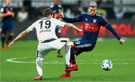  ?? — Reuters ?? That’s mine: Bayern Munich’s Robert Lewandowsk­i (right) vying for the ball with Eintracht Frankfurt’s David Abraham during the Bundesliga match at the Commerzban­kArena on Saturday.