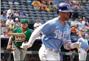  ?? CHARLIE RIEDEL / AP ?? Oakland Athletics starting pitcher Jared Koenig throws to first for the out hit into by Kansas City Royals’ Whit Merrifield, right, during the third inning of a baseball game on Saturday in Kansas City, Mo.