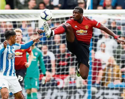  ??  ?? Watch out: Manchester United’s Paul Pogba (right) vying for the ball with Huddersfie­ld’s Juninho Bacuna during the Premier League match at the the John Smith’s Stadium on Sunday. — Reuters