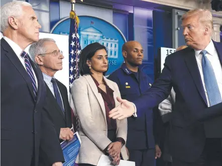  ??  ?? GEARING UP: Donald Trump gestures to National Institute of Allergy and Infectious Diseases director Anthony Fauci at a briefing.