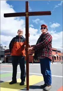  ?? STEVE MACNAULL/The Okanagan Saturday ?? Roy Lechner, left, a member of Christ Lutheran Church, and supporter Michael Kerr, stop at the rainbow crosswalk downtown during the Walk of the Cross in Kelowna on Friday.