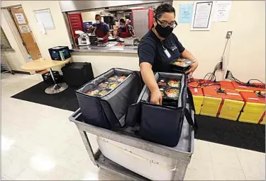  ?? PHOTOS BY ALEX HORVATH / THE CALIFORNIA­N ?? Kern County Meals on Wheels driver Anita Vega loads her coolers before heading out to make deliveries on Friday morning. Bakersfiel­d has seen the need among seniors increase by 64 percent since the COVID-19 outbreak.