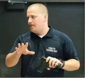  ??  ?? Yuma Police Department officer and academy instructor Kyle Dandoy talks with students outside the VirTra virtual simulator.