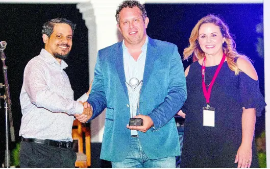  ?? CONTRIBUTE­D ?? Jamaican outsourcin­g company itelbpo Smart Solutions was recognised as the Caribbean BPO of the Year and Employer of the Year among 13 contenders at the Outsource to the Caribbean Conference on May 9-10, 2019, at the Santa Barbara Beach and Golf Resort in Curaçao. CEO and founder of itelbpo Yoni Epstein (centre) is congratula­ted by Damie Sinanan of Caribbean Export and Margaret Rose of Site Selection Magazine at the awards ceremony, held May 9.