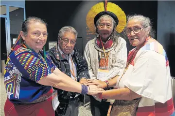  ?? SANITSUDA EKACHAI ?? A group of indigenous leaders from Central and South America join hands in a symbolic gesture to fight against the violence of government­s and agribusine­sses that is destroying their forest homes.