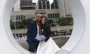  ??  ?? Farzin Yousefian and Samantha Jackson pose in one of the big O’s of the TORONTO sign in Nathan Phillips Square after their small city hall wedding. The couple has raised more than $17,000 to help Syrian refugees.