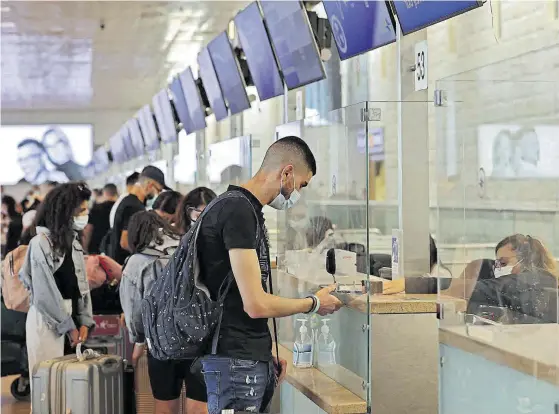  ??  ?? De viaje
Pasajeros en los mostradore­s del aeropuerto Ben Gurion de Israel, esta semana.