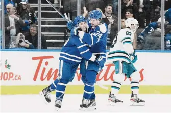  ?? Chris Young/Associated Press ?? Toronto’s Mitch Marner (left) celebrates after his empty-net goal against the Sharks.