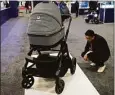  ?? ?? An attendee looks at the GluxKind Ella motorized smart stroller during the CES tech show Thursday in Las Vegas.