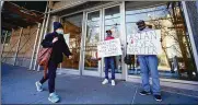  ?? AP ?? Activists Calvin, right, and Cameron Hunt show support for the Asian community outside the building where an Asian American woman was assaulted Tuesday.