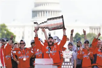  ?? Jacquelyn Martin / Associated Press ?? Washington Capitals captain and winger Alex Ovechkin hoists the Stanley Cup trophy near the U.S. Capitol during Tuesday’s other victory parade — the one for the NHL champions.