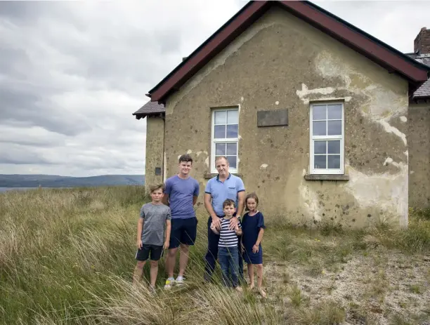  ??  ?? ABOVE: David Campion and his children, Ethan, Killian, Sam and Lily outside the schoolhous­e just above Lough Allen in Leitrim. David deliberate­ly kept the exterior of the house as it was when he bought it to reflect its history, while the interior is an example of low-energy luxury livingTOP RIGHT: Lily and Sam in the hot tub, which is filled by rainwater, against the fabulous backdrop of Lough AllenRIGHT: The winter living room which retains the original flat roof. The wood-burning stove is inset into the original mantlepiec­e. The stainless-steel windows are done in white in keeping with the original look and feel of the schoolhous­eABOVE RIGHT: Ethan in one of the bedrooms; the original roof was flat, but David opened it up to create a mezzanine for bedrooms