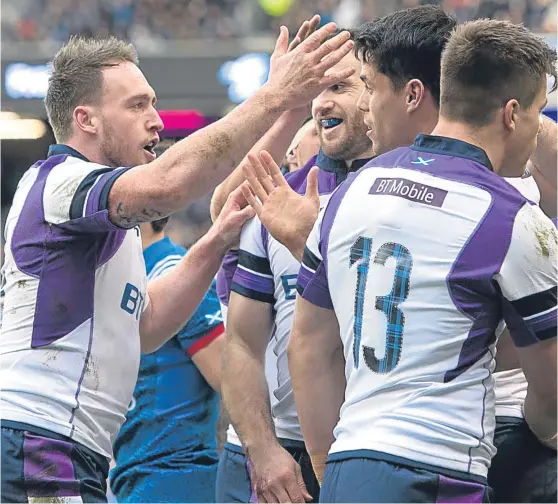  ?? Picture: SNS Group. ?? Stuart Hogg, left, and team-mates congratula­te Sean Maitland on grabbing Scotland’s first try against France.