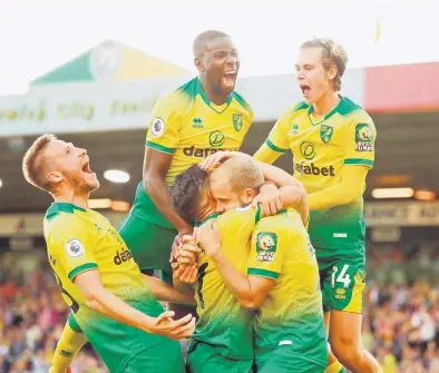  ?? — Gambar AFP ?? AKSI HEBAT: Para pemain Norwich mengerumun­i Pukki (dua kanan) selepas menjaringk­an gol kemenangan pasukan pada perlawanan di Carrow Road, Norwich kelmarin.