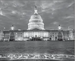  ?? AP/J. DAVID AKE ?? Lights shine inside the U.S. Capitol as night falls Sunday in Washington and as Congress continues to negotiate during the second day of the federal government shutdown.