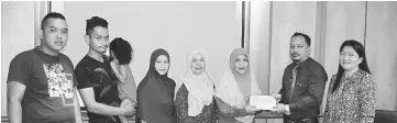  ??  ?? Hendera (second right) handing over the cheque to Naemah at the Miri Socso office yesterday in the presence of Neili (far right), Mislia (fourth right) and some of Naemah’s children.